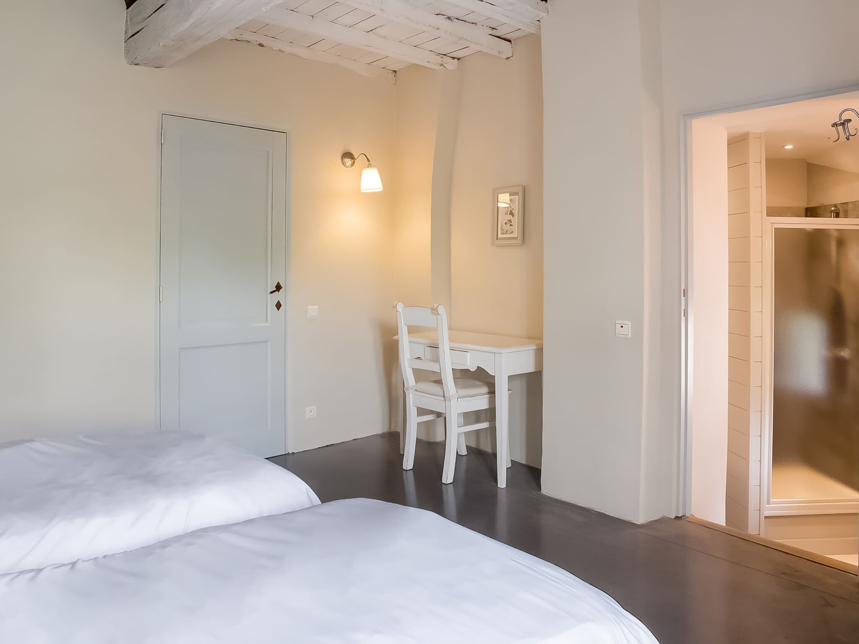 Un dormitorio con cama, escritorio y silla.