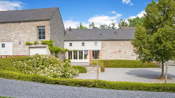A stone building with a gravel driveway and well-maintained hedges. - Getaway With Sauna in Falaen (Onhaye)