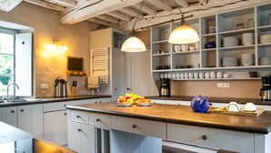 A modern kitchen with a large island, white cabinets, and a variety of kitchen appliances. - Getaway With Sauna in Falaen (Onhaye)