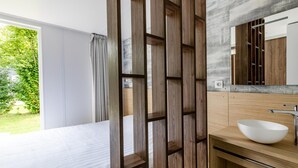 A modern bathroom with a large mirror, a white sink, and a wooden partition. - Chalet in Baalse Hei With Modern Comforts (Turnhout)
