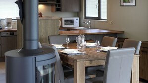 A modern kitchen with a dining area, including a stove, microwave, and sink. - Nice Luxuriuos Villa With Sauna, Located in a Lake Area (Froidchapelle)