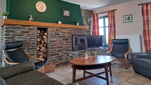 A cozy living room with a stone fireplace, a television, and comfortable seating. - Gîte L'olivier à Filly - Nadrin, Entre Houffalize et La Roche-en-ardenne (Houffalize)