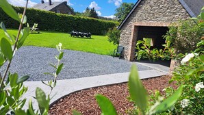 A stone building with a brick entrance, a gravel driveway, and a green lawn with a picnic table. - Gîte L'olivier à Filly - Nadrin, Entre Houffalize et La Roche-en-ardenne (Houffalize)