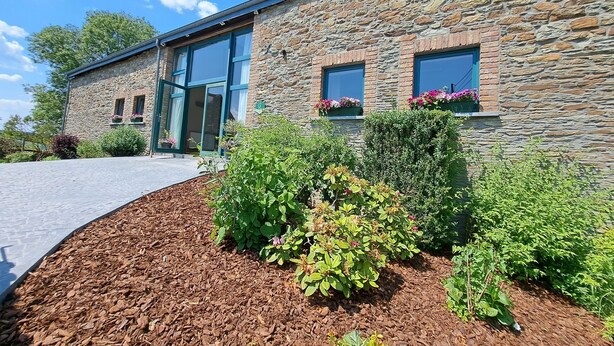 A stone building with large windows and a landscaped garden area. - Gîte L'olivier à Filly - Nadrin, Entre Houffalize et La Roche-en-ardenne (Houffalize)