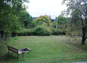 A grassy area with a bench and a fire pit. - Chalet in Belgium Surrounded by Nature (Viroinval)