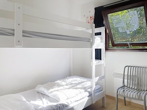 A bunk bed with a lower bunk and a chair next to a window with a view of greenery. - Chalet in Belgium Surrounded by Nature (Viroinval)