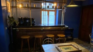 A bar area with wooden stools, a bar counter, and a framed picture on the table. - Holiday Home in Semois Valley Near Kayaking (Vresse-sur-Semois)