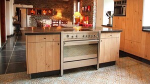 A modern kitchen with a central island, built-in oven, and wooden cabinets. - Holiday Home in Semois Valley Near Kayaking (Vresse-sur-Semois)