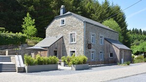 A stone building with a sloped roof, a wooden extension, and a gravel driveway. - Cozy Holiday Home in Gedinne near Forest (Gedinne)