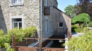 A stone building with a wooden extension, a metal gate with decorative patterns, and a small window. - Cozy Holiday Home in Gedinne near Forest (Gedinne)