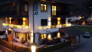 Ein mehrstöckiges Gebäude mit Balkonen, einem Schild mit der Aufschrift "Apartment Zillertal" und Außenbereichen mit Sitzgelegenheiten.