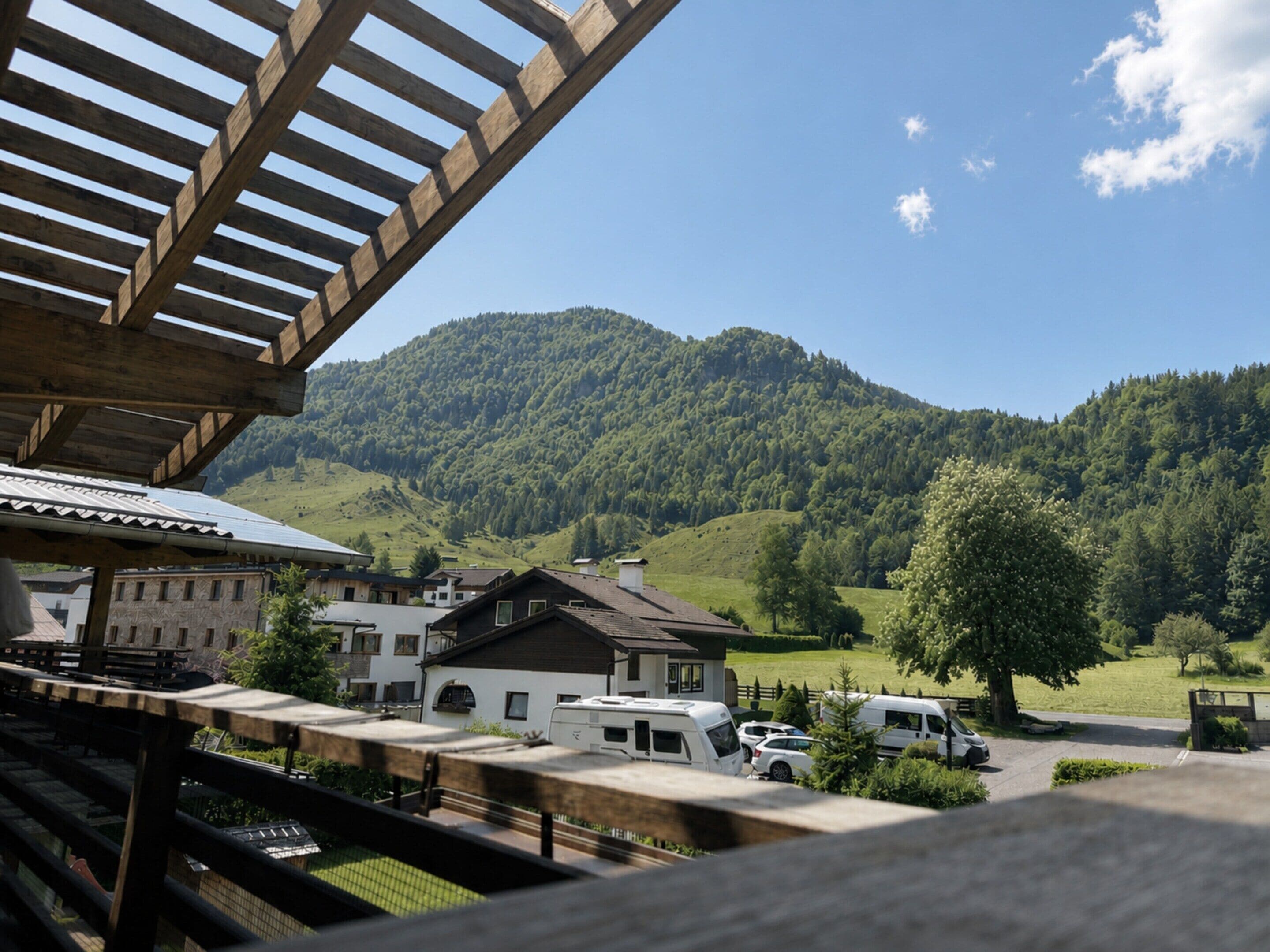 A view of a mountain landscape with a wooden structure in the foreground.