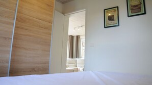 A bedroom with a wooden wardrobe, a bed, and two framed quotes on the wall. - Holiday Home in Duruby With Garden & BBQ (Durbuy)