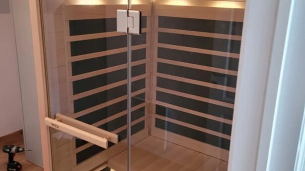 A corner room with a glass door, a wooden floor, and a white wall with horizontal lines. - Holiday Home in Barvaux With Sauna & Garden (Durbuy)