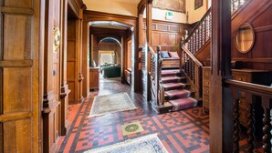A grand hallway with wooden doors and a staircase with red carpeted steps. - Impressive Castle in Spa With a Swimming Pool (Jalhay)