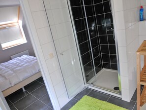 Un bagno con doccia, WC e lavandino.