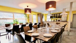 A dining area with a long table set for a meal, surrounded by chairs. - Holiday Home in Stoumont With Private Sauna (Stoumont)