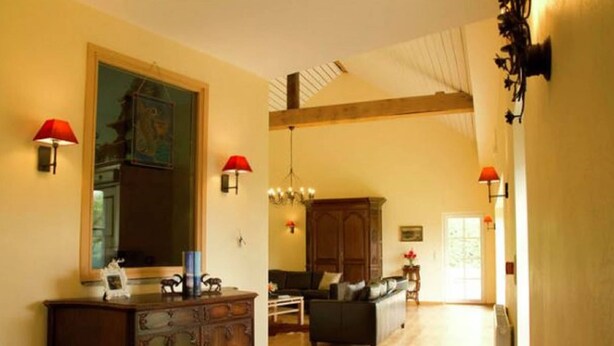 Un amplio salón con un gran aparador de madera, una mesa de comedor y un sofá.