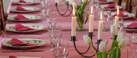 A table set for dining with plates, glasses, and candles.