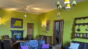 A living room with a fireplace, leather sofas, a coffee table, and a chandelier. - House near Caves of Hotton, L' Ourthe, & Durbuy (Somme-Leuze)