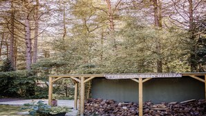 Une structure en bois sur laquelle est apposée une enseigne portant l'inscription « Tijd Vuur Construktie ».