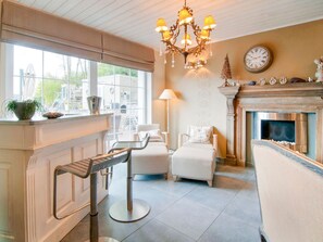 A modern living room with a fireplace, a chandelier, and a view of the outside. - Fauvillers Spa Haven, Bastogne (Fauvillers)