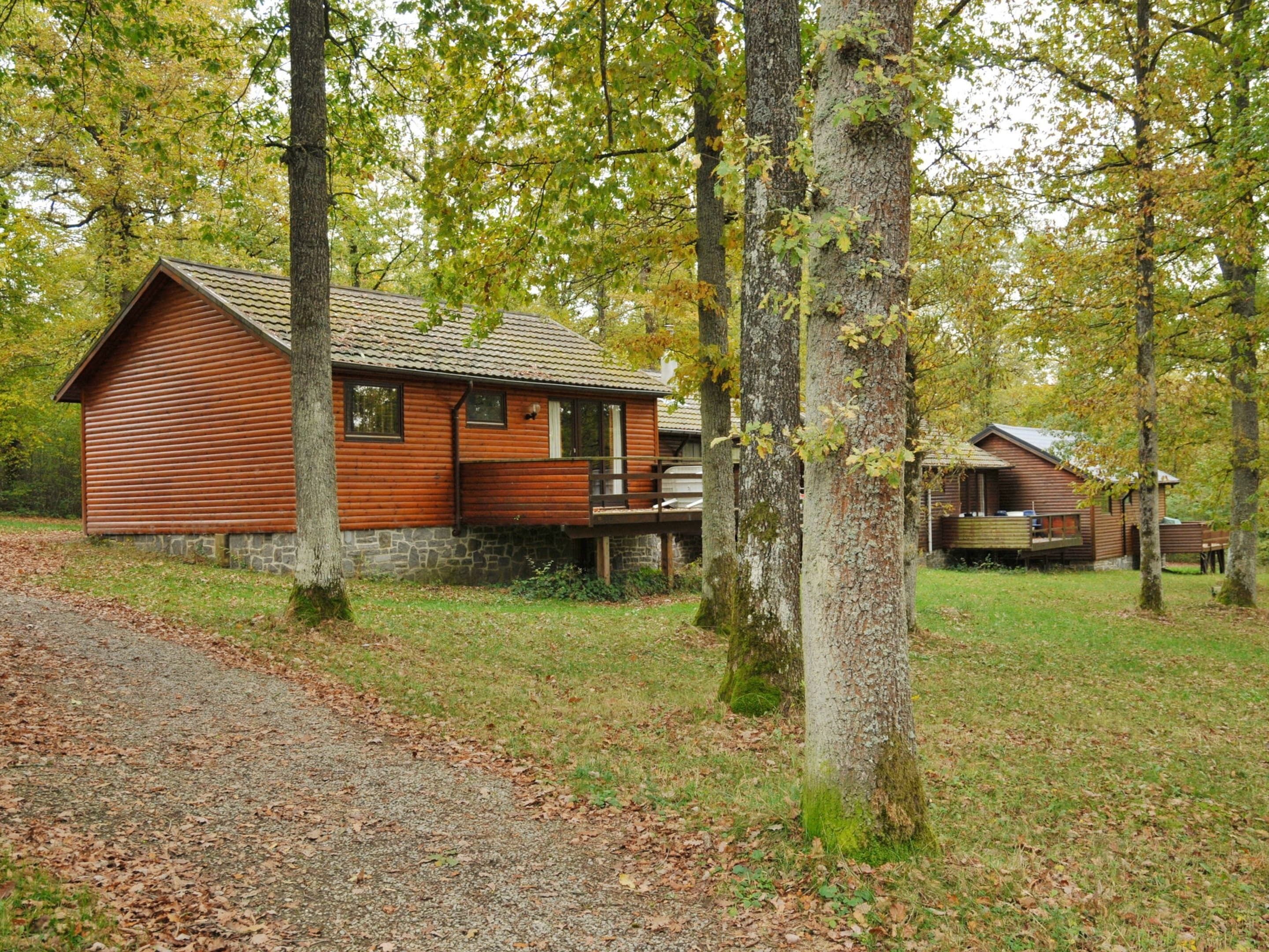 A rustic cabin with a stone foundation, wooden exterior, and a porch.
