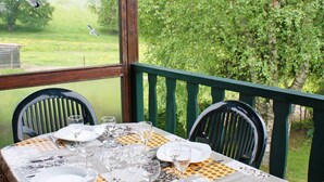 A table set for four with a view of a green landscape and trees. - Longfaye Chalet With Sauna (Malmedy)