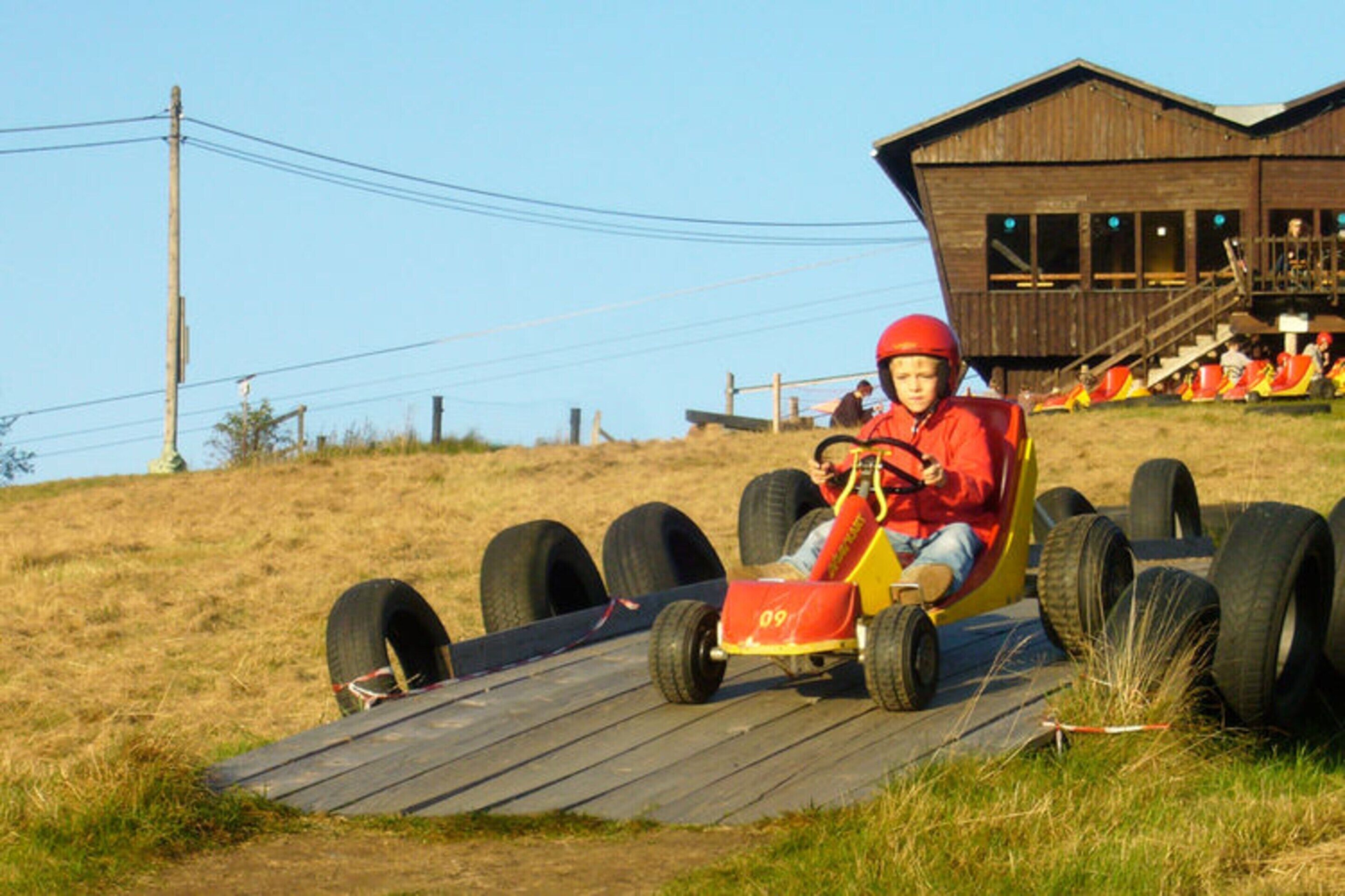 A go-kart track with a wooden building in the background.