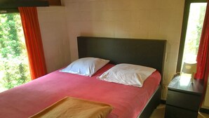 A bed with a red bedspread, two white pillows, and a brown towel. - Nicely Furnished Bungalow with Fireplace near Maas (Hastiere)