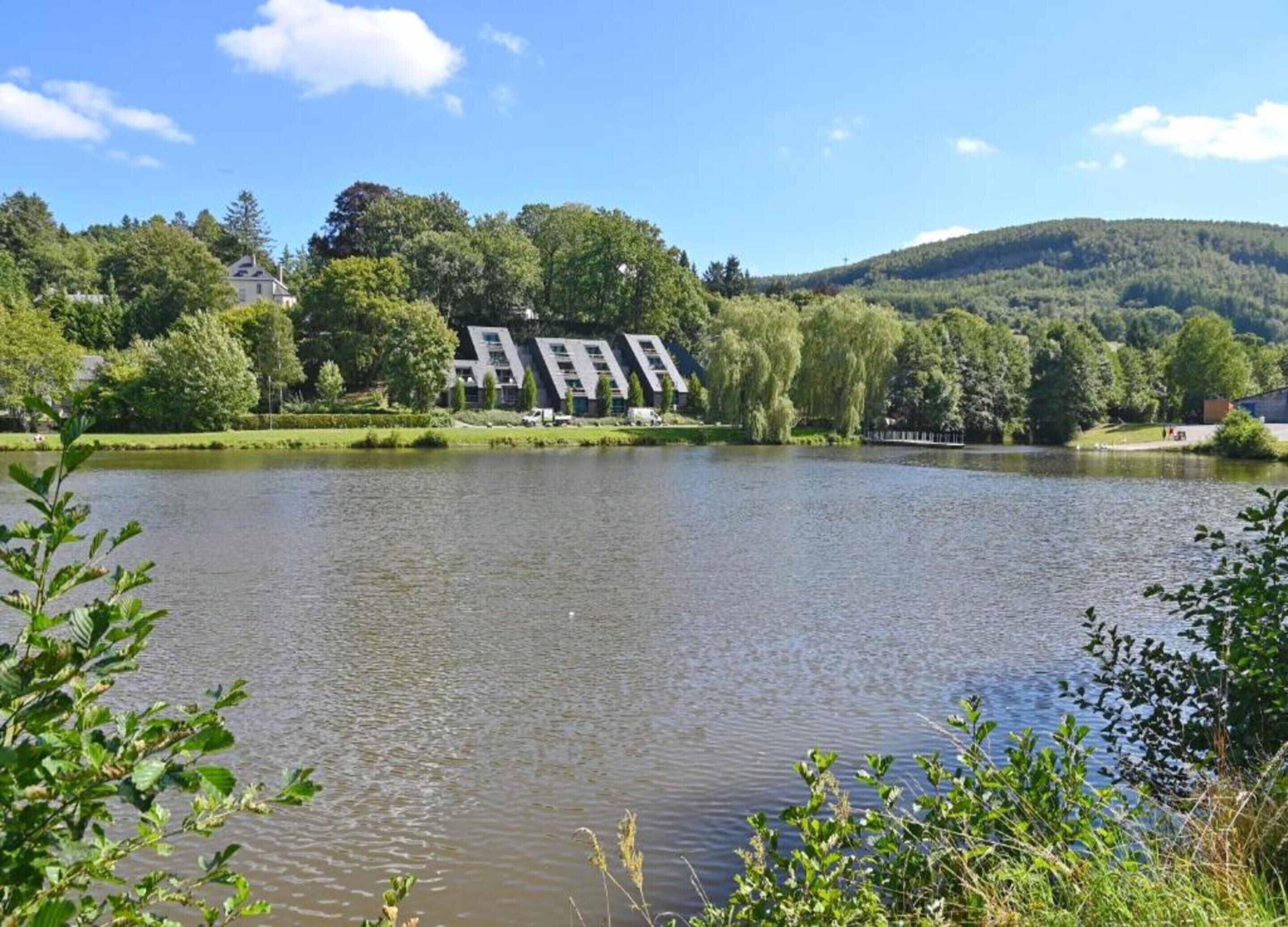 Ein See mit einem Gebäude im Hintergrund.