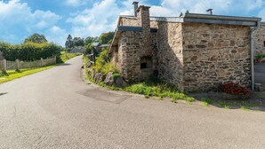 A stone building with a sloped roof, a small window, and a door. - Lierneux Family Nature Stay (Lierneux)
