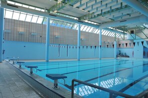 An indoor swimming pool with clear lanes, a diving board, and a tiled floor. - Well-kept Apartment Near Durbuy (Durbuy)