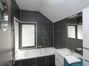 Un bagno moderno con una vasca, una doccia e un lavandino.