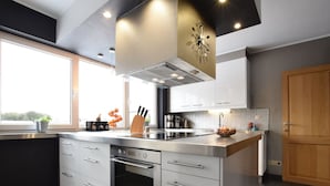 Una cocina moderna con una isla central, electrodomésticos de acero inoxidable y un amplio ventanal que proporciona luz natural.
