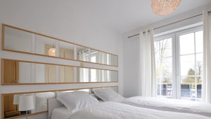 Habitación de hotel con dos camas, un espejo grande y una ventana con cortinas.