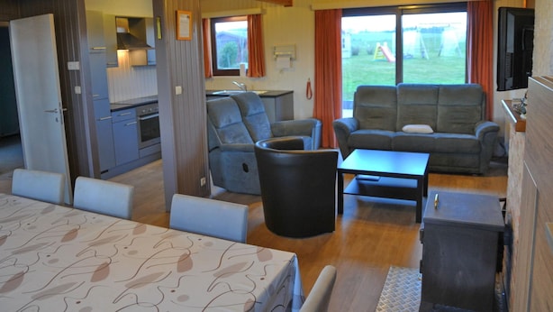 Un intérieur de chalet chaleureux comprenant un coin repas, une cuisine et un espace salon.