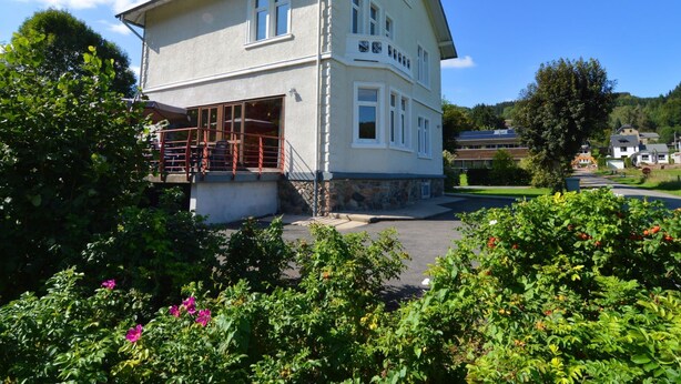 A two-story building with a balcony and a covered outdoor seating area. - Beautiful Holiday Home in Malmedy-beverce With Sauna (Malmedy)