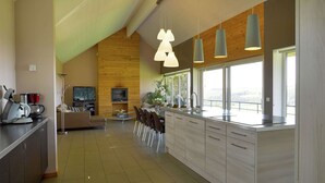 Une cuisine moderne dotée d’un grand îlot central, de touches de bois et d’un coin repas offrant une vue agréable.