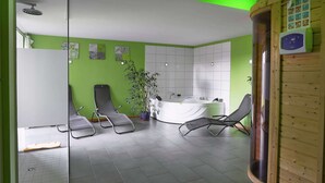 Une salle de bain moderne avec une baignoire, une douche et deux fauteuils.