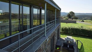 Un bâtiment moderne doté de grandes fenêtres offrant une vue imprenable sur un paysage verdoyant.