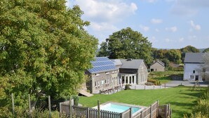 A residential property with a swimming pool, solar panels, and a fenced yard. - Holiday Home in Ardennes With Pool & Sauna (Vielsalm)