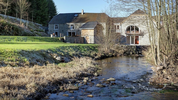 A stone house with a river in front, surrounded by trees and a grassy area. - Cozy Holiday Home in Gedinne near Forest (Gedinne)