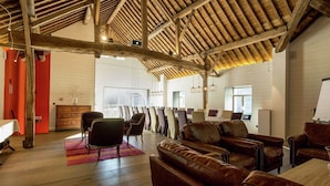 A spacious room with wooden beams, leather sofas, and a large dining table. - Cozy Holiday Home in Gedinne near Forest (Gedinne)