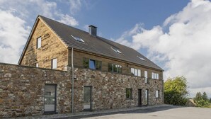 En moderne bygning med en stenfasad og et skråt tag.