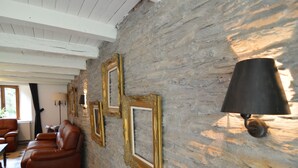 A room with a stone wall, a brown leather sofa, and a lamp. - Peaceful Holiday Home With Garden in Fauvillers Belgium (Fauvillers)