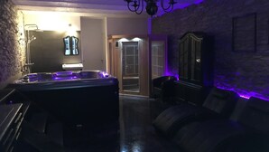 A dimly lit room with a large hot tub, a stone wall, and a wooden cabinet. - Peaceful Holiday Home With Garden in Fauvillers Belgium (Fauvillers)