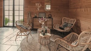 A cozy room with wicker furniture, a round rug, and a small table with decorative items. - Castle Farmhouse in Condroz With Heated Pool (Ohey)