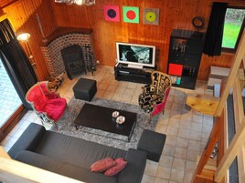 A cozy living room with a fireplace, a TV, and a comfortable seating area.
