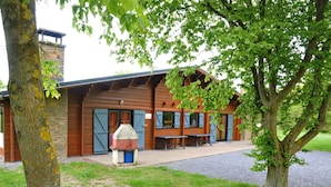 A rustic building with a stone facade, wooden beams, and a covered seating area. - Holiday Home in Houyet With Sauna & Garden (Houyet)